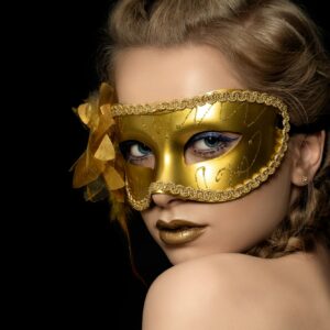 Young beautiful woman wearing golden party mask