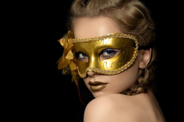 Young beautiful woman wearing golden party mask